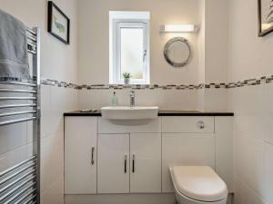 a white bathroom with a sink and a toilet at 4 Bed in Swanage oc-dc217 in Langton Matravers +21 photos