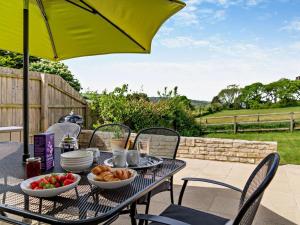 a table with bowls of food and an umbrella at 4 Bed in Swanage oc-dc217 in Langton Matravers