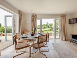 a dining room with a table and chairs and a couch at 4 Bed in Swanage oc-dc217 in Langton Matravers