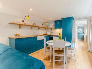a kitchen with blue cabinets and a table and chairs at 1 Bed in Wincanton oc-83499 in Hilton