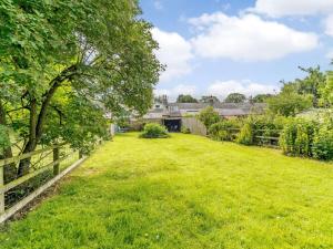 a grassy yard with a fence and trees at 1 Bed in Hexham oc-89085 in Bellingham