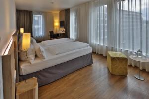 a bedroom with a large bed in a room with windows at Hotel Goldenes Rad in Ulm