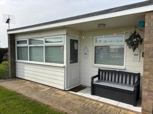 a garage with a bench in front of a house at 179, Two bed chalet on Sund0wner Holiday Park - Sleeps 4, free WiFi, sorry no pets - entertainment options close by in Hemsby +9 photos