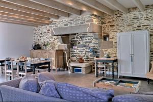 a living room with a couch and a stone wall at Maison d'hôtes KerCalow, Chambres d'hôtes in Pleine-Fougères