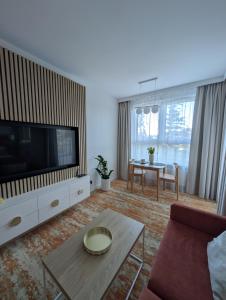 a living room with a television and a table at BelMare 327 Aqua in Międzyzdroje