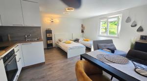 a kitchen and living room with a table and a couch at Le Petit Beurre de cacahuète et Le Poivre et Sel in Fully