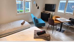 a living room with a bed and a table and chairs at Le Petit Beurre de cacahuète et Le Poivre et Sel in Fully