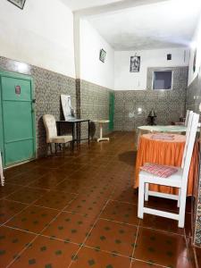 a room with a table and chairs on a floor at Chambres et table d'hôtes Caracalla in Douar Doukkara