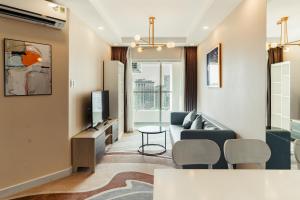 a living room with a couch and a tv at La Living Collection in Ho Chi Minh City