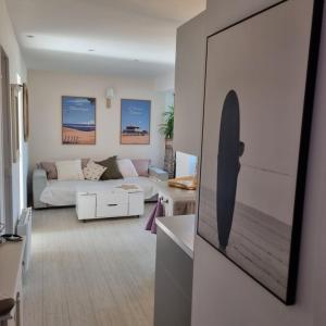 a living room with a couch and a surfboard on the wall at On the Beach in Lacanau-Océan