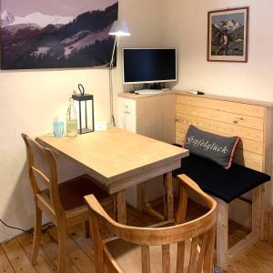 a wooden table with chairs and a television in a room at Landhaus Wahmbeck in Wahmbeck