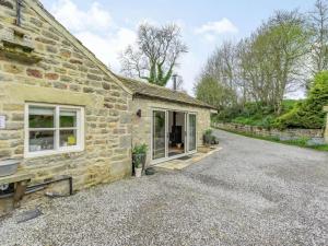a stone house with a gravel driveway next to a building at 3 Bed in Nr Masham oc-g0149 in Healey