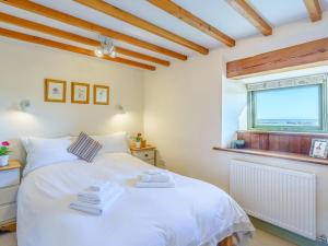 a bedroom with a white bed and a window at 2 Bed in Berwick -upon- Tweed oc-36344 in Kyloe