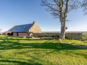 an old stone barn with a tree in a field at 2 Bed in Berwick -upon- Tweed oc-36344 in Kyloe