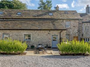 an old stone house with a patio in front of it at 3 Bed in Skipton oc-84014 in Rylstone
