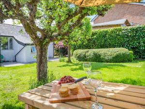 a wooden table with a cutting board with glasses of wine at 2 Bed in Lymington oc-87885 in Sway