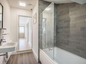 a bathroom with a tub and a sink and a mirror at 2 Bed in Lymington oc-87885 in Sway +12 photos