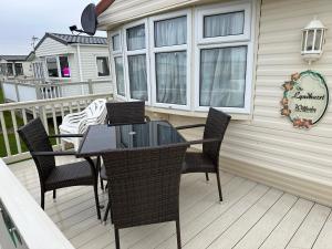 a patio with a table and chairs on a deck at Luxury Caravan Coastfields Holiday Village in Ingoldmells