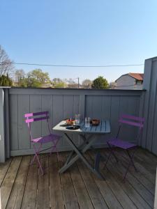 a table and two chairs on a deck at le coulinet in Andernos-les-Bains