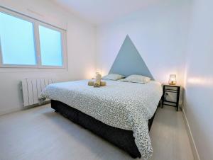a bedroom with a bed with a geometric headboard at L'Échappée Verte - Maison familiale avec Jardin & Parking - 20 min du PuyduFou in Mauléon