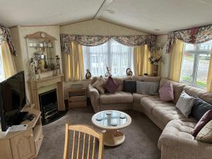 a living room with a couch and a tv at Luxury Caravan Coastfields Holiday Village in Ingoldmells
