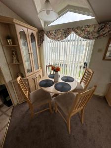 a dining room with a table and chairs and a window at Luxury Caravan Coastfields Holiday Village in Ingoldmells