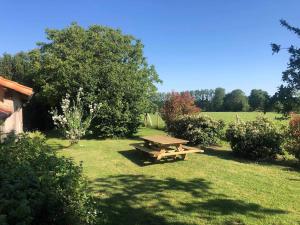 a picnic table in the middle of a field at L'Échappée Verte - Maison familiale avec Jardin & Parking - 20 min du PuyduFou in Mauléon