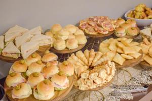 a table with many different types of sandwiches and pies at Alfa Plaza Hotel in Brasília