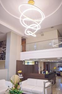 a lobby with white furniture and a large chandelier at Alfa Plaza Hotel in Brasília