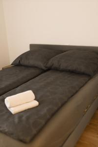 a black bed with two white towels on it at Haus Auf Bulz - Klippeneck in Denkingen