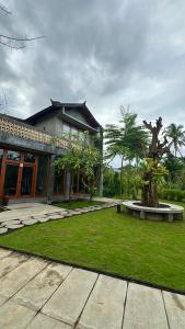a house with a tree in the middle of a yard at Rumah Hadeka sawan in Sawan
