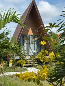 a small house with yellow flowers in front of it at Bà Đen Garden - Hương Sen Quán in Tây Ninh