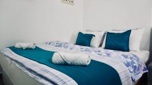 a large bed with blue and white sheets and pillows at Villa Tex in Neum