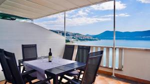 a table on a balcony with a view of the water at Villa Tex in Neum
