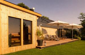 a house with a deck with two umbrellas at Poziom 511 Jura Wellness Hotel & Spa in Ogrodzieniec