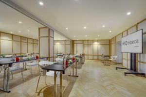 a restaurant with tables and chairs and a sign at H10 Tribeca in Madrid +43 photos