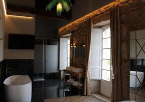 a bathroom with a tub and a sink and a mirror at Hospedium Hotel Barómetro de Camariñas in Camariñas