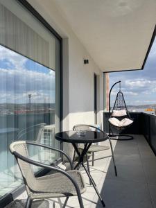 a balcony with two chairs and a table on a balcony at Cashmere Apartment in Cluj-Napoca