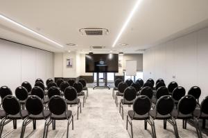 a conference room with chairs and a projection screen at Hotel Le Bois De Bruges in Bruges