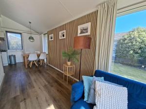 a living room with a blue couch and a table at Bungalow 024 in Petten