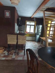a kitchen with a table and chairs and a refrigerator at Balto kalno namai, Kernavėje in Kernavė
