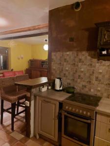 a kitchen with a stove and a counter with a table at Balto kalno namai, Kernavėje in Kernavė