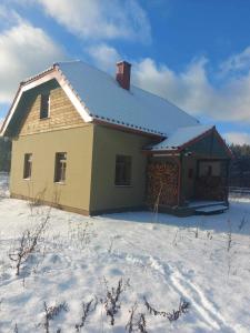 a house with snow on the roof in the snow at Balto kalno namai, Kernavėje in Kernavė