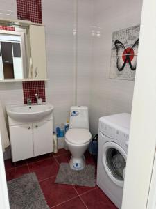 a bathroom with a toilet and a washing machine at Apartments Chaiky Kyiv in Chayky