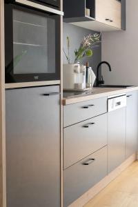 a kitchen with white cabinets and a microwave at Suites am Herzogberg in Brunn am Gebirge