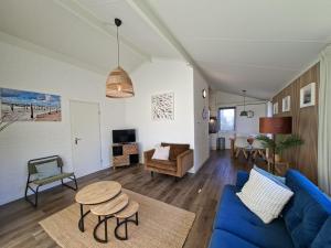 a living room with a blue couch and a table at Bungalow 024 in Petten
