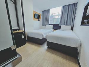 a hotel room with two beds and a television at Ekonomy Hotel Myeongdong Premier in Seoul