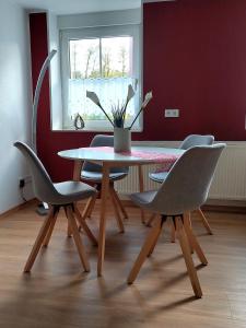 a dining room table with chairs and a potted plant at Ferienwohnung "Kleiner" EIFELTRAUM in Mettendorf