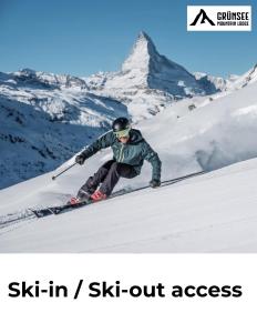 a man is skiing down a snow covered mountain at Grünsee Mountain Lodge in Zermatt