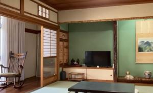 a living room with a tv and a chair and a table at Sane Yanagisawa in Awaji